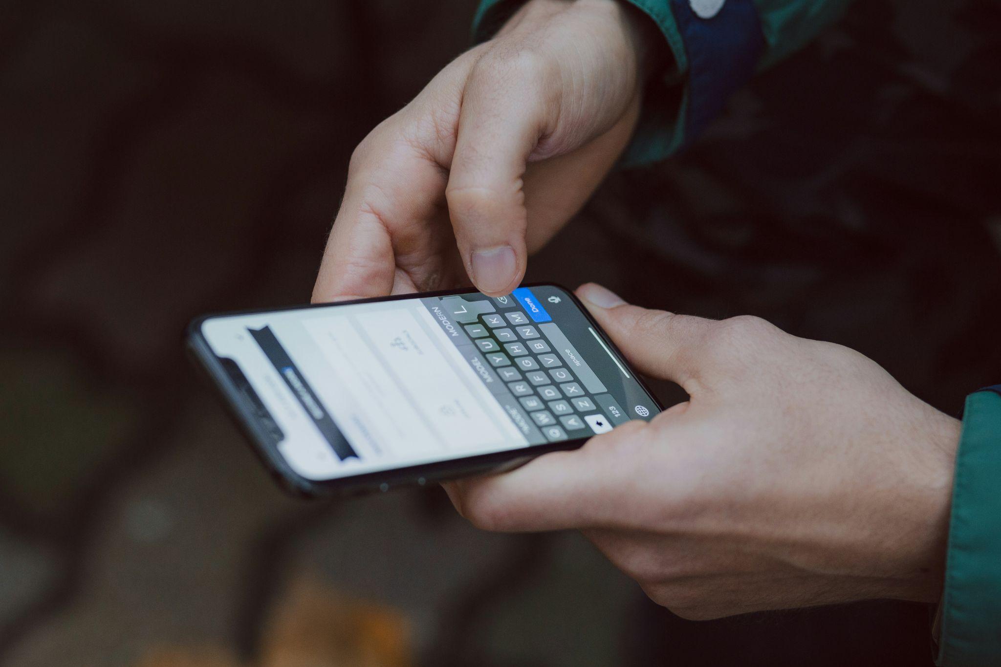 A person types a message on a smartphone, representing missed call text back services in California.