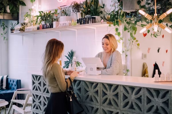 Traditional receptionist greeting a visitor at a front desk in California office